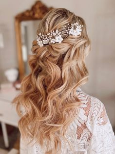 a woman with long blonde hair and flowers in her hair is looking into the mirror