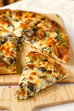 a sliced pizza sitting on top of a wooden cutting board