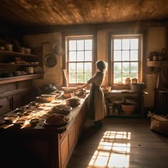 a woman standing in front of a kitchen counter with food on the counter and windows