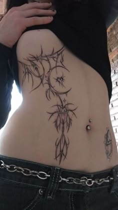 a woman's stomach with tattoos on it