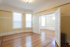 an empty room with hard wood floors and white trim on the walls is shown in this image