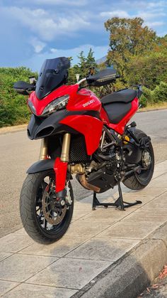 a red motorcycle is parked on the side of the road