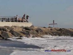 people are standing on the rocks by the water and looking out at the waves in the ocean