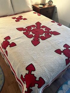 a bed with a red and white quilt on it