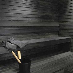 a black and white photo of a sauna in a wooden room with a towel on the bench