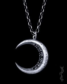 a silver crescent pendant on a black background