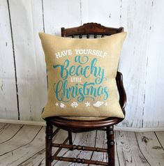 a pillow that says have yourself a beachy little christmas on it sitting in a chair