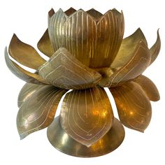 a gold colored metal flower on a white background