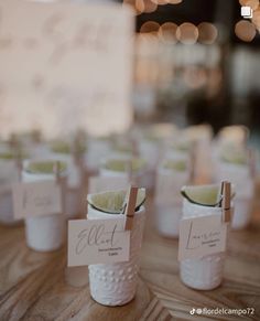 there are many small cups with limes in them on the table, and one has a name tag attached to it