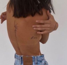 the back of a woman's body with tattoos on it