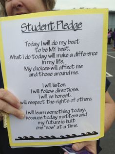 a woman holding up a sign that reads student pledge today i will do my best