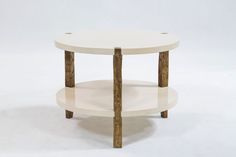 a white table with two wooden legs and a round shelf on the bottom that is made out of wood