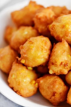 a white bowl filled with fried food on top of a table