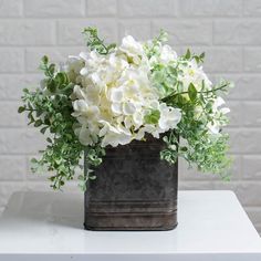 a white flower arrangement sitting on top of a table