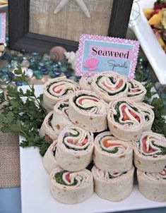 a table topped with lots of different types of sandwiches and wrappers on top of each other