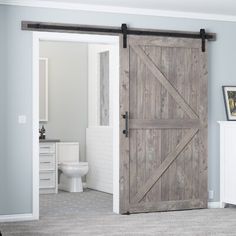 a bathroom with a sliding barn door next to a toilet