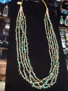 "- PLEASE contact me before purchase if you are interested in this item. The gallery has a few to choose from that are very similar. - Santo Domingo Pueblo artist Daniel Calabasa, Native American Indian made, vintage, mostly green American turquoise & shell heishi 5 multi-strand necklace... in an old classic style. With very small heishi shell beads. Turquoise beads in irregular shapes & sizes, yet all quite similar... Unusual interesting finish is woven nylon. Hangs 16\" 137R - This stu Cheap Turquoise Beaded Necklaces For Festivals, Southwestern Green Turquoise Necklace, Southwestern Style Green Single Strand Jewelry, Hand-strung Green Beaded Necklaces Southwestern Style, Southwestern Turquoise Heishi Beads Jewelry, Old Classic Style, Pueblo Native Americans, Heishi Necklace, Irregular Shapes