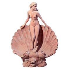 a statue of a woman standing on top of a shell