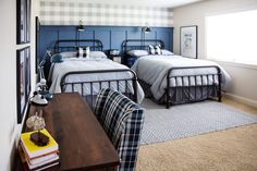 a room with two beds and a couch in it, next to a table that has a book on top of it