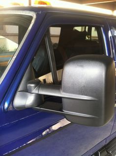 the side view mirror of a blue pick up truck