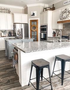 a kitchen with two stools next to an island