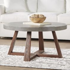 a white couch sitting next to a wooden table on top of a carpeted floor