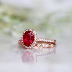 Beautiful Vintage Inspired Ruby Ring ►Base Metal: Sterling Silver (S925) ►Plating: 14K Rose Gold Vermeil ►Accented With Simulated Diamonds ►Can be paired with one or two half-eternity Milgrain bands of your choice Center Stone: Ruby Grade: AAA Stone Cut: Oval Gem size: 8.0 x 6.0 mm Carat Weight: 1.21 ct. Gemstone creation: 100% Genuine Lab-Grown Ruby Stone Origin: Russia ►Please be aware that plated jewelry can wear off over time, if this is a concern we would suggest going with the sterling sil Classic Bridal Set With Halo Setting For Anniversary, Classic Ruby Ring With Halo Design, Classic Ruby Ring For Anniversary On Valentine's Day, Classic Ruby Ring For Anniversary And Valentine's Day, Classic Jewelry With Halo Design For Marriage, Classic Halo Design Jewelry For Marriage, Classic Rings With Prong Setting For Valentine's Day, Wedding 14k Rose Gold Stackable Rings, Classic 14k Gold Ruby Ring With Halo Design