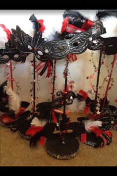 masquerade masks are lined up on the floor in front of a white wall