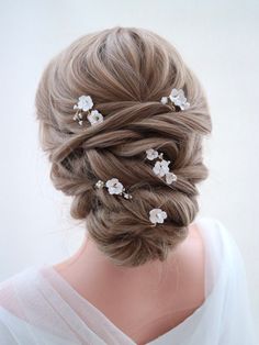 a woman with blonde hair and flowers in her hair is wearing a white dress, while she