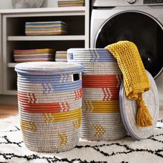 two baskets sitting on top of a rug next to a washer and dryer