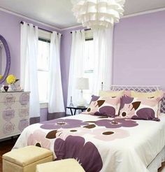 a bedroom with purple walls and white furniture in the corner, along with a large mirror on the wall