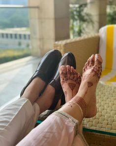 a woman's feet with hendix on them sitting in front of a window