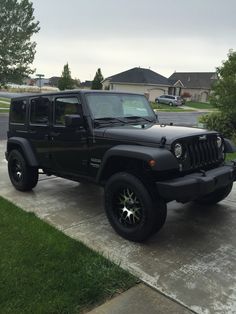 a black jeep is parked in the driveway