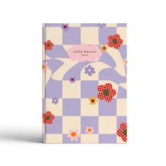 a purple and white checkered book with flowers on the cover, sitting against a white background