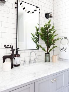 a bathroom sink with a mirror above it and a christmas tree on the counter top