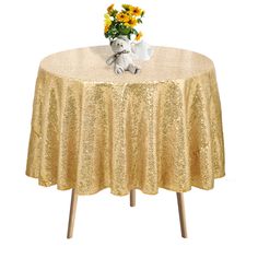 a teddy bear sitting on top of a table covered in gold sequins and flowers