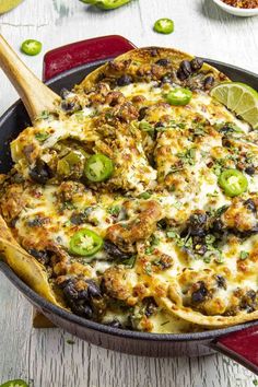 a casserole dish with green peppers, onions and cheese in a red cast iron skillet