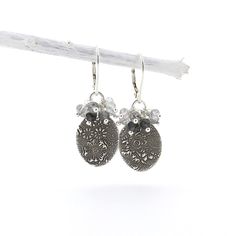 Dainty and modern, these beaded gemstone dangle Lily Earrings consist of handmade Sterling Silver 0.5 inch textured ovals, featuring my Floral Bouquet pattern, dangling under a small cluster of 3.5mm Black Rutilated Quartz faceted gemstone rondelles in a shaded mix of black to white.  The earrings are PETITE at approximately 1.5 inches from the top of the Sterling Silver Lever Backs to the bottom of the ovals.  The ovals have been oxidized, buffed by hand and tumble polished while the remainder Silver Dangle Beaded Earrings With Natural Stones, Silver Beaded Drop Earrings With Natural Stones, Silver Dangle Earrings With Natural Stones, Silver Jewelry With Dangling Beads For Everyday, Silver Dangle Beaded Earrings For Everyday, Lily Earrings, Black Rutilated Quartz, Jewelry Unique, Cluster Earrings