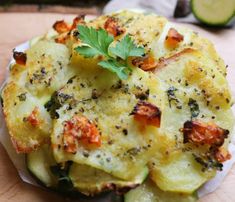 some food that is sitting on top of a wooden cutting board next to cucumber slices