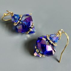 "Purple and Gold  Earrings - Glass Iridescent Purple  Beads with Gold Plated Beadcaps and Iridescent Purple Bacon Glass Beads. These earrings have a lot of sparkle and are gorgeous when the light hits them. The Beads are approximately 14mm wide Gold plated Earwires Earrings measure  1.25\" long from top of earwire to bottom" Elegant Iridescent Crystal Earrings Gift, Elegant Iridescent Crystal Earrings, Handmade Iridescent Crystal Earrings For Party, Party Jewelry With Iridescent Ear Wire, Iridescent Party Earrings, Pierced Iridescent Jewelry For Party, Iridescent Drop Earrings For Formal Occasions, Elegant Handmade Iridescent Beaded Earrings, Iridescent Pierced Jewelry For Party