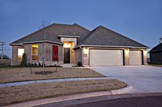 a house that is lit up in the evening with lights on it's windows