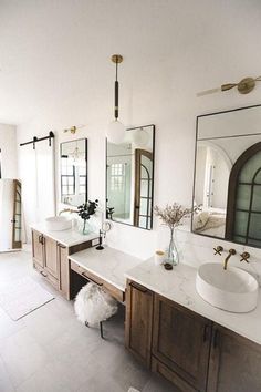 a bathroom with two sinks and mirrors in it