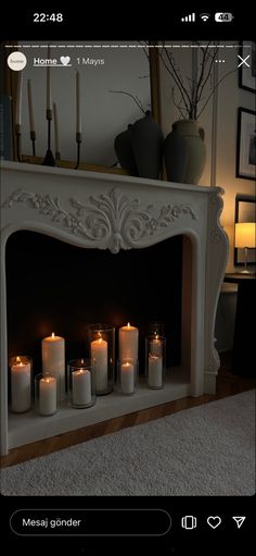 candles are lit in front of a fireplace