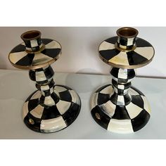 two black and white checkered candlesticks sitting on top of each other