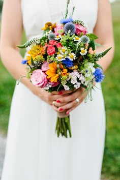 a woman holding a bouquet of flowers in her hands