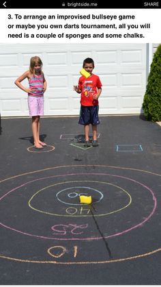 two young children standing in front of a chalk drawing on the ground with words below