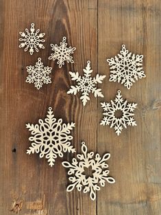 four snowflakes are sitting on a wooden surface