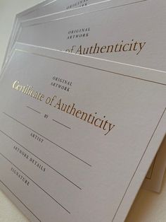 three certificates sitting on top of each other with gold foil lettering in the middle