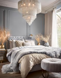 a bedroom with a large bed and chandelier hanging from the ceiling