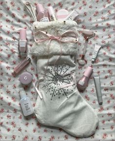 the contents of a personal care bag are laid out on a floral print sheet with pink flowers